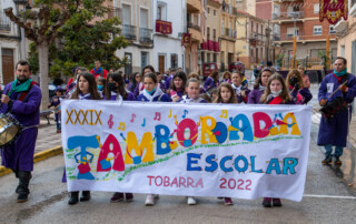 Niños y niñas de Tobarra llevando la pancarta de la Tamborada Escolar 2022 en la tarde de Miércoles Santo. Semana Santa de Tobarra